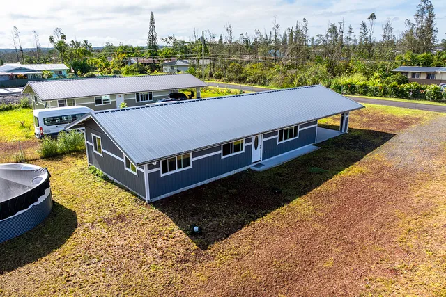 a view of a swimming pool with lawn chairs and a yard