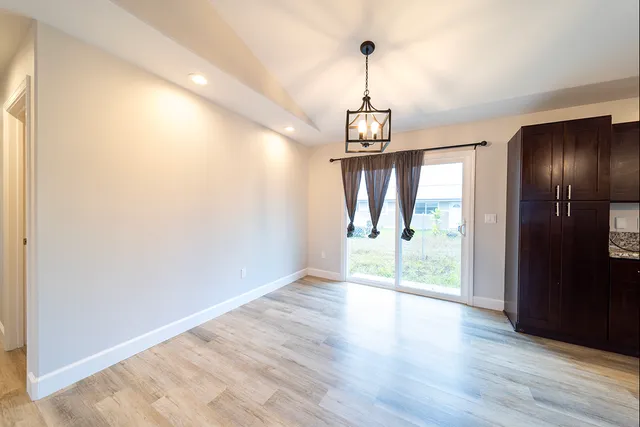 a view of empty room with wooden floor and window