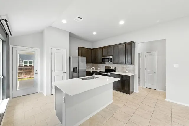 a kitchen with a sink a stove cabinets and refrigerator