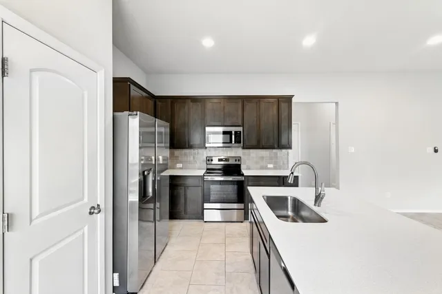 a kitchen with stainless steel appliances a refrigerator stove and sink