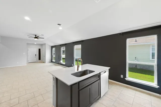 a kitchen with stainless steel appliances granite countertop a sink and a refrigerator