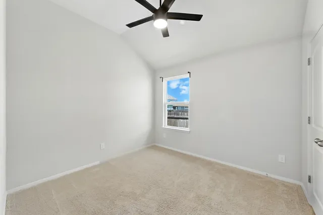 an empty room with a window and a fan