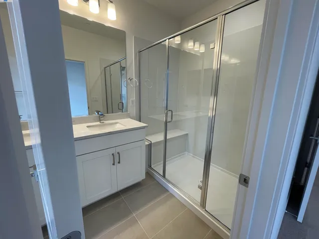 a bathroom with a shower sink and mirror