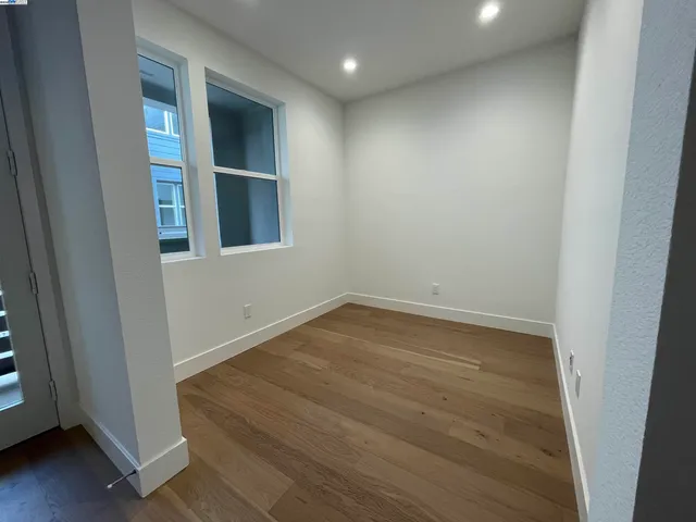 an empty room with wooden floor and entrance