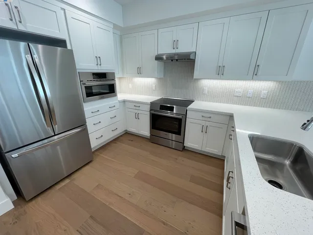 a kitchen with stainless steel appliances a refrigerator sink and cabinets