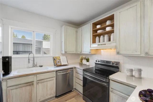 a kitchen with stainless steel appliances granite countertop a sink stove and cabinets