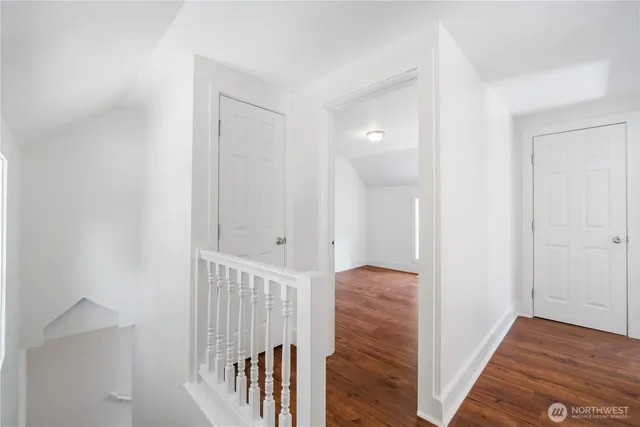 a view of a hallway with wooden floor and staircase