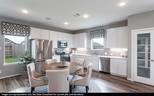 a kitchen with refrigerator and chairs