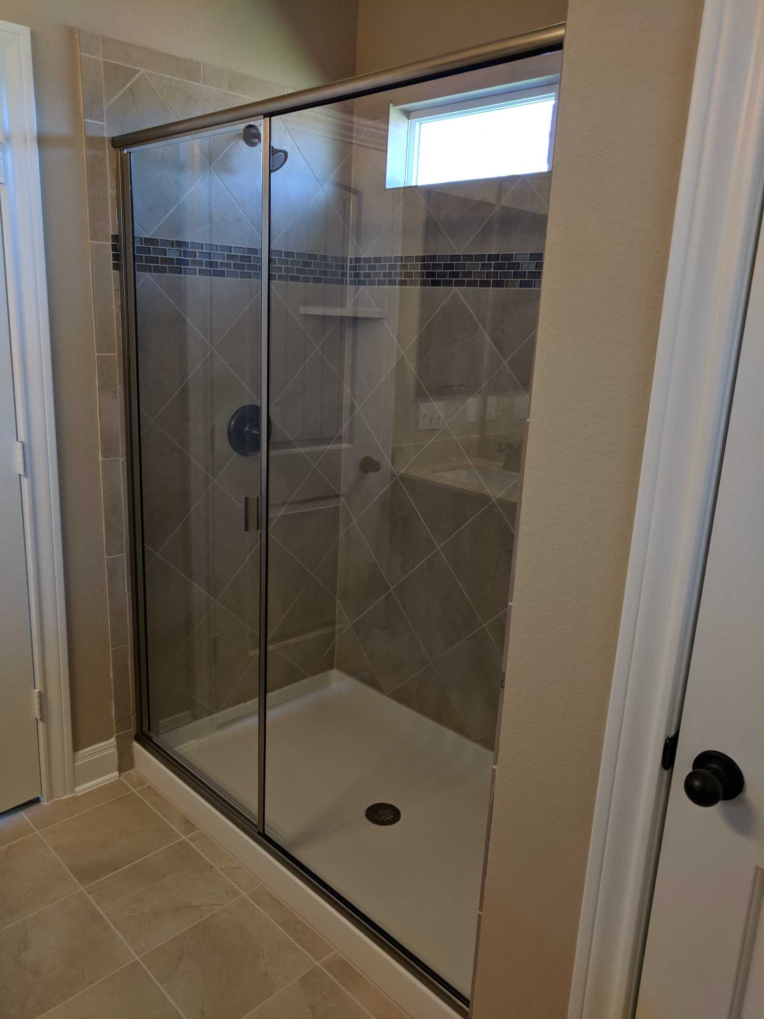 2471 Sunrise Road, Unit 8 Round Rock, TX 78664 - Photo 6 of 13 Glass-enclosed shower featuring a tiled surround with a decorative accent band and a built-in niche