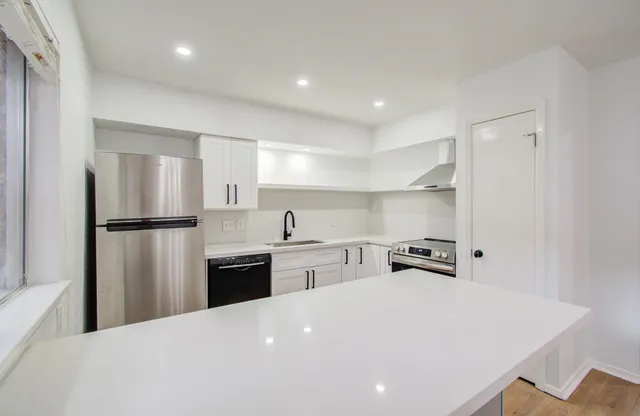 a kitchen with refrigerator and chairs