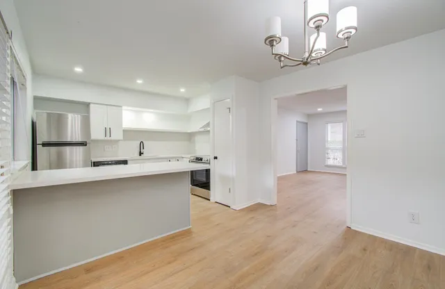a view of a kitchen with a sink stainless steel appliances and cabinets