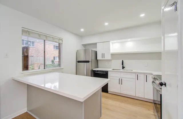a kitchen with white cabinets and white appliances