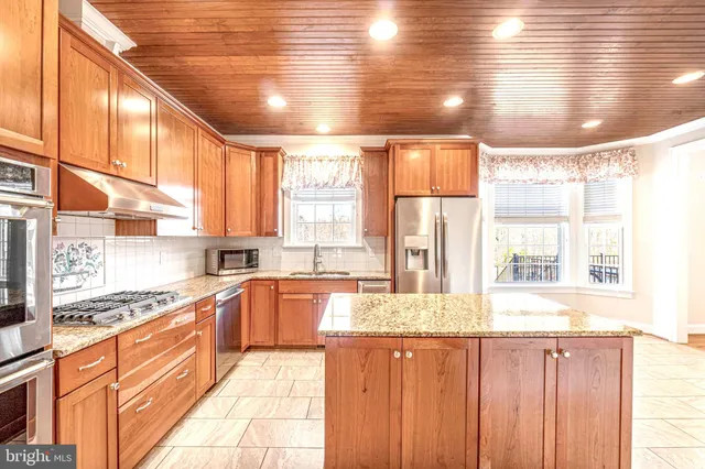 a bathroom with a granite countertop sink a toilet and shower