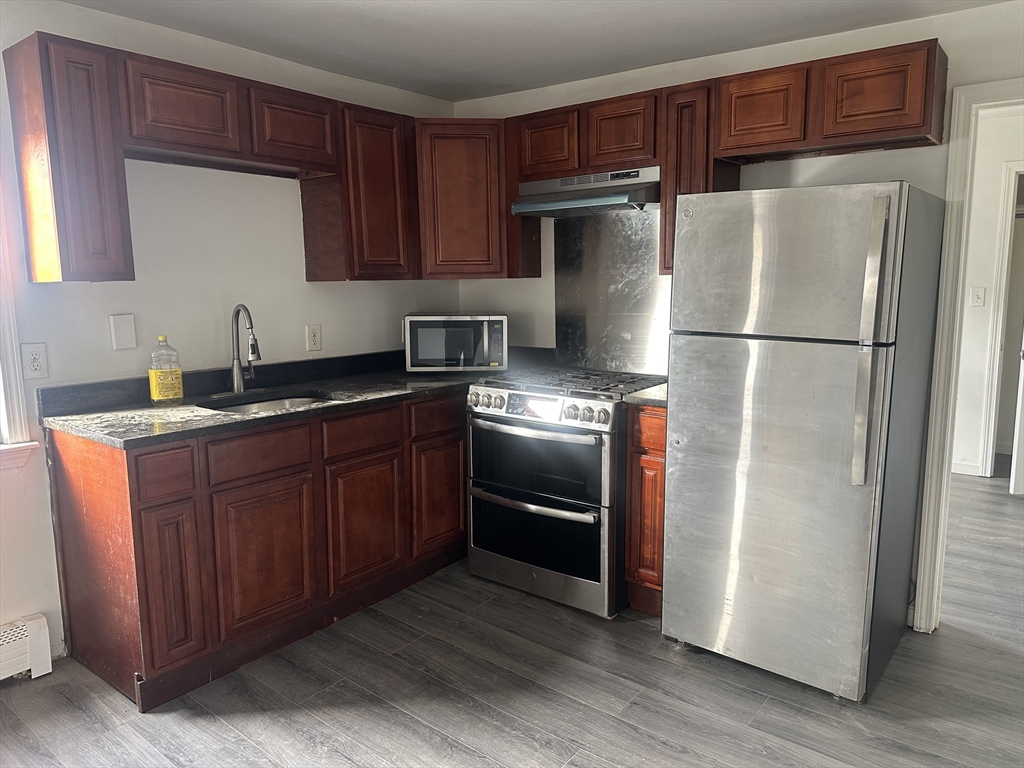 a kitchen with stainless steel appliances granite countertop a refrigerator and a stove top oven