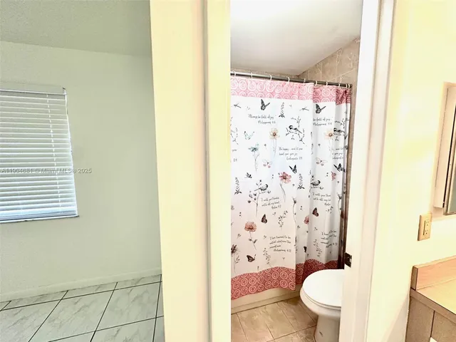 a bathroom with a shower curtain and a toilet
