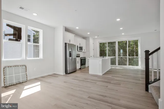 a view of kitchen with refrigerator and wooden floor