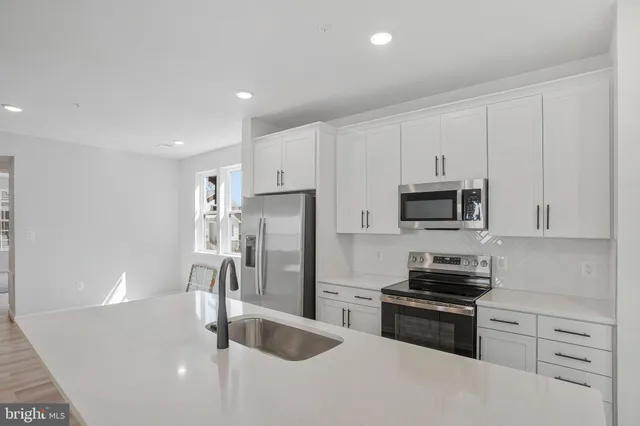 a kitchen with stainless steel appliances granite countertop a refrigerator sink and stove