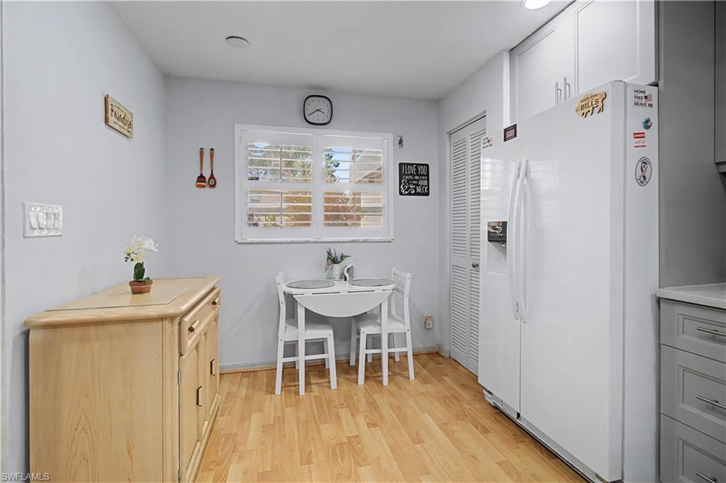 741 Landover Circle, Unit 102 Naples, FL 34104 - Photo 11 of 27 a view of a dining room with furniture window and wooden floor