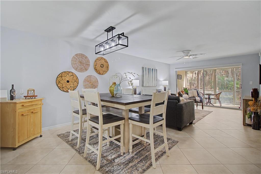 741 Landover Circle, Unit 102 Naples, FL 34104 - Photo 13 of 27 a view of a dining room and hall with furniture