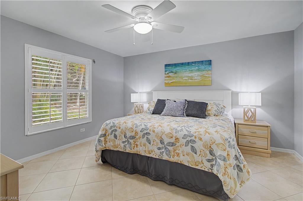741 Landover Circle, Unit 102 Naples, FL 34104 - Photo 17 of 27 a bedroom with a bed and window