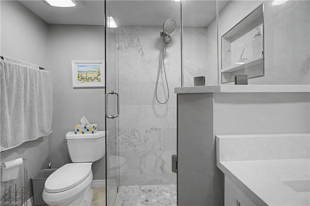 741 Landover Circle, Unit 102 Naples, FL 34104 - Photo 20 of 27 a bathroom with a toilet sink and shower