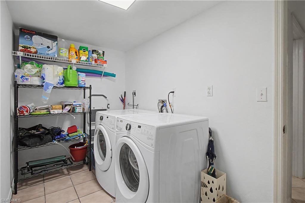 741 Landover Circle, Unit 102 Naples, FL 34104 - Photo 23 of 27 a utility room with dryer and washer