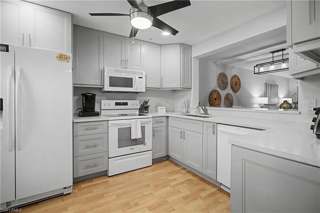 741 Landover Circle, Unit 102 Naples, FL 34104 - Photo 7 of 27 a kitchen with cabinets stainless steel appliances and a window