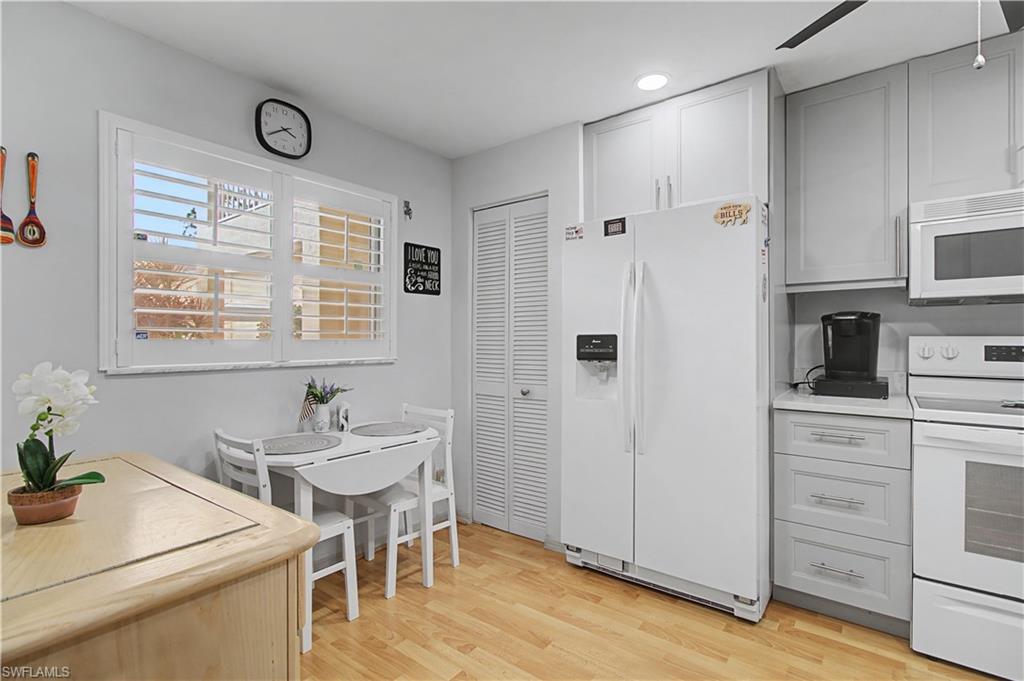 741 Landover Circle, Unit 102 Naples, FL 34104 - Photo 9 of 27 a kitchen with a sink cabinets and wooden floor