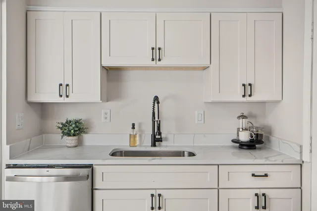 a kitchen with white cabinets and a sink