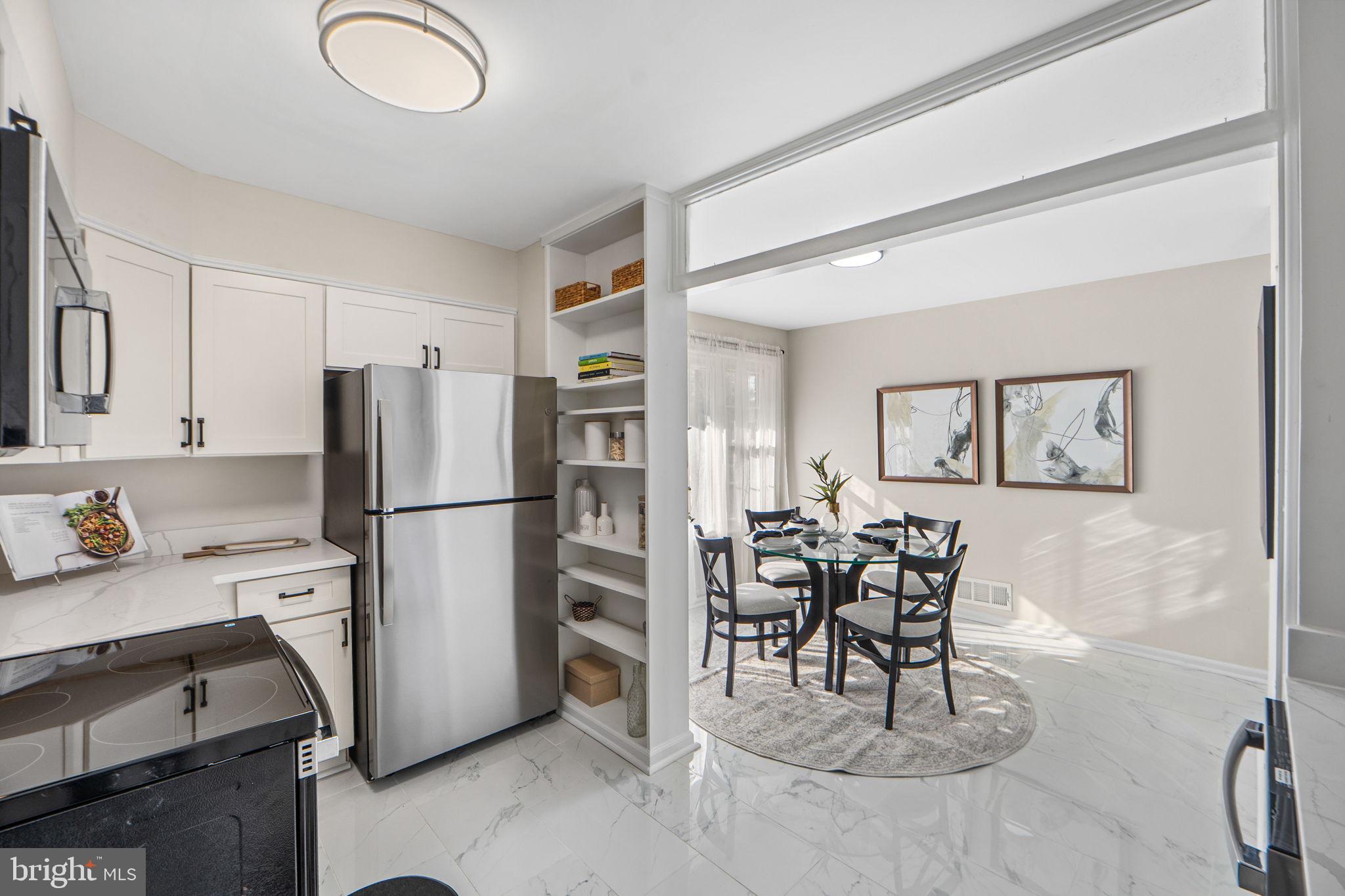 1513 Flora Lane Silver Spring, MD 20910 - Photo 13 of 50 a kitchen with stainless steel appliances a refrigerator a stove a dining table and chairs with wooden floor