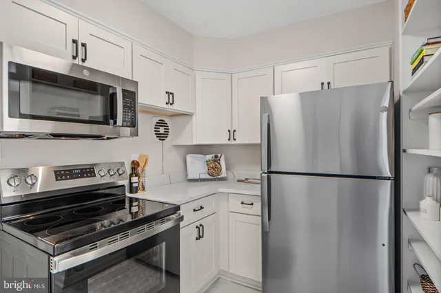 a kitchen with stainless steel appliances a refrigerator stove and microwave