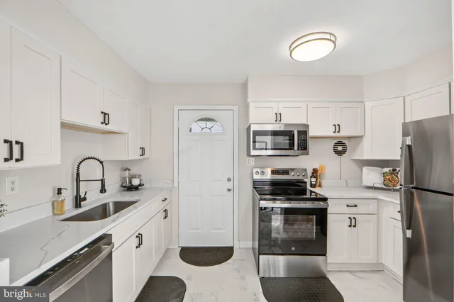 a kitchen with stainless steel appliances a refrigerator stove and sink