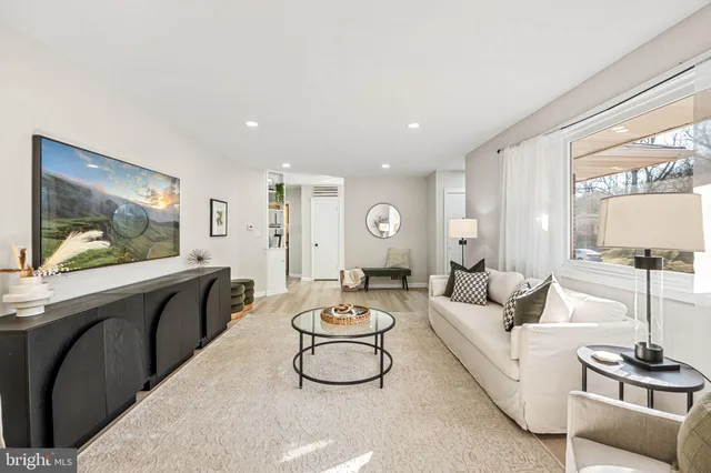 a living room with furniture a rug and white walls
