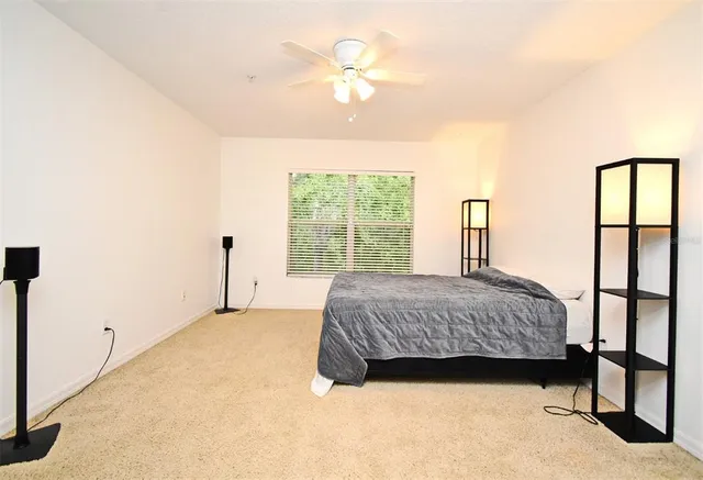 a spacious bedroom with a large bed and a chandelier