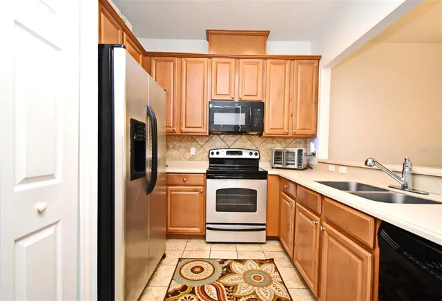 a kitchen with a sink a microwave a refrigerator and cabinets