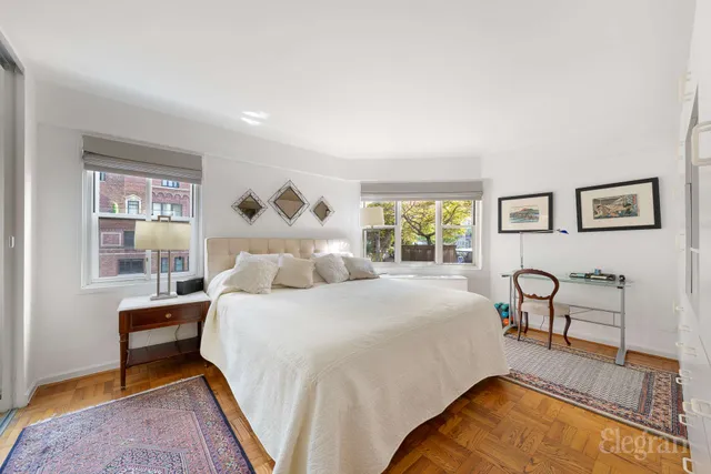 a bedroom with a bed and a dresser next to a window