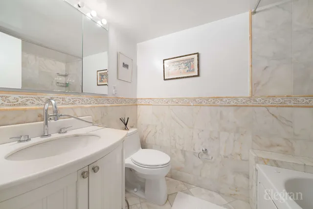 a bathroom with a toilet sink and mirror