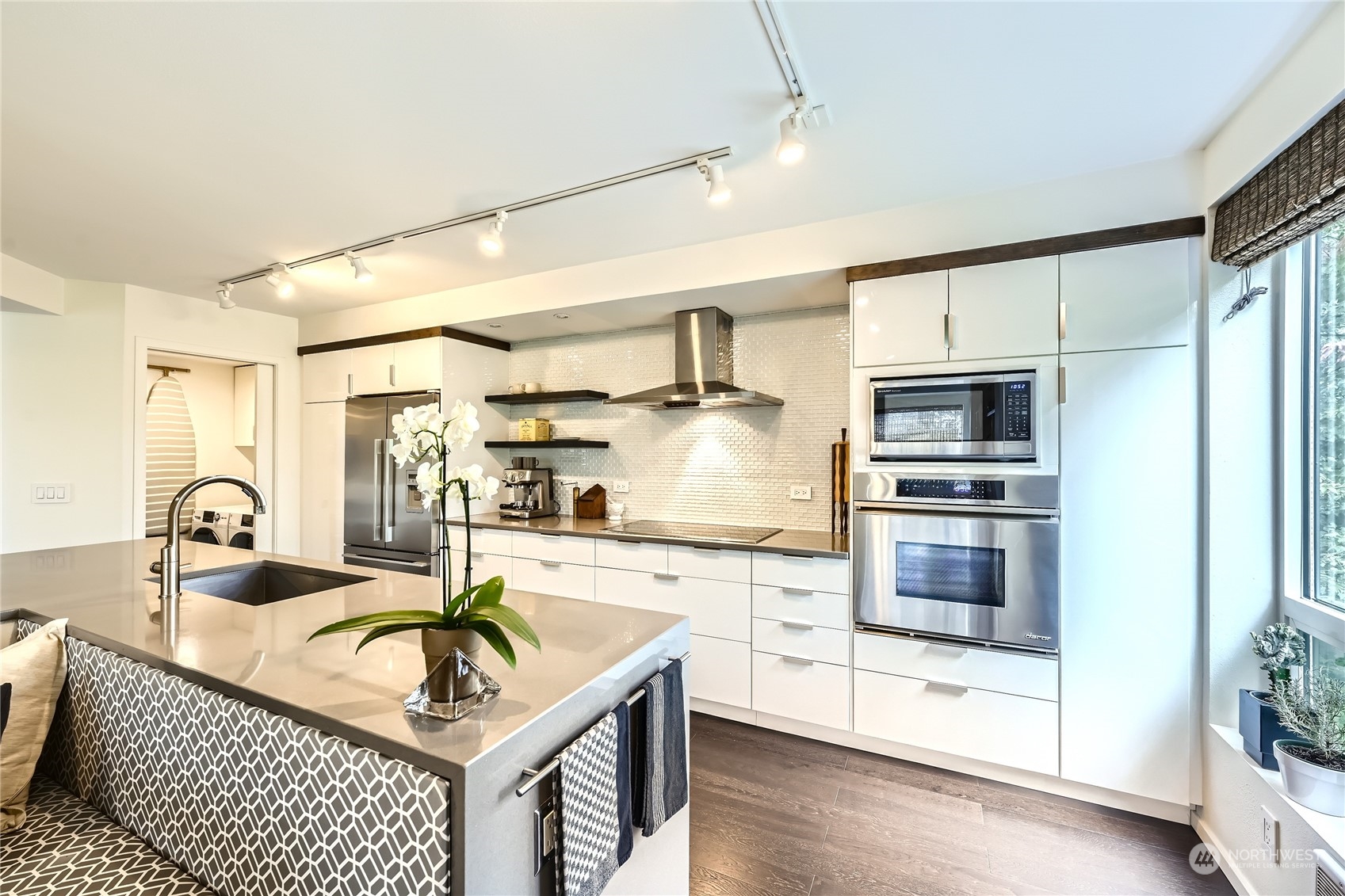 619 5th Avenue West, Unit 401 Seattle, WA 98119 - Photo 8 of 29 a kitchen with stainless steel appliances granite countertop a sink dishwasher a refrigerator and a stove with wooden floor