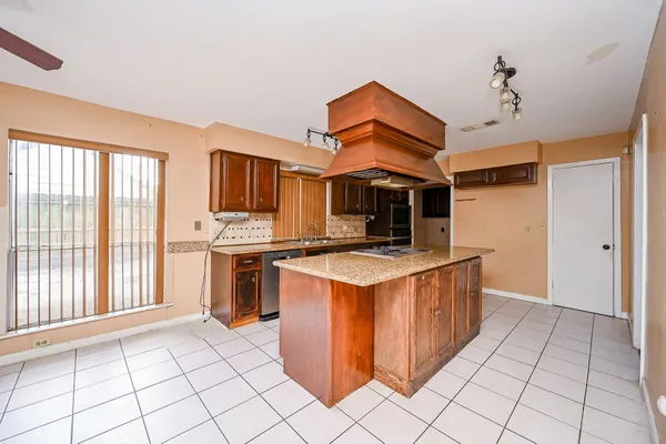 a kitchen with a stove top oven cabinets and a refrigerator
