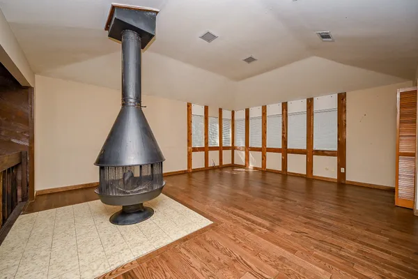 a empty room with wooden floor table and chairs
