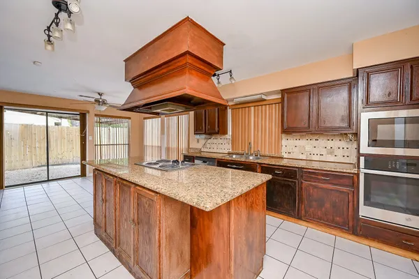 a kitchen with stainless steel appliances granite countertop a stove a sink and a microwave