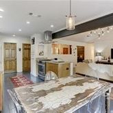 a large kitchen with kitchen island a large counter top space appliances and cabinets