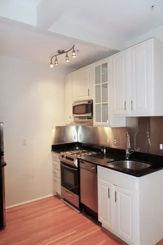 a kitchen with granite countertop stainless steel appliances and white cabinets