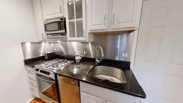 a kitchen with a sink a stove and cabinets