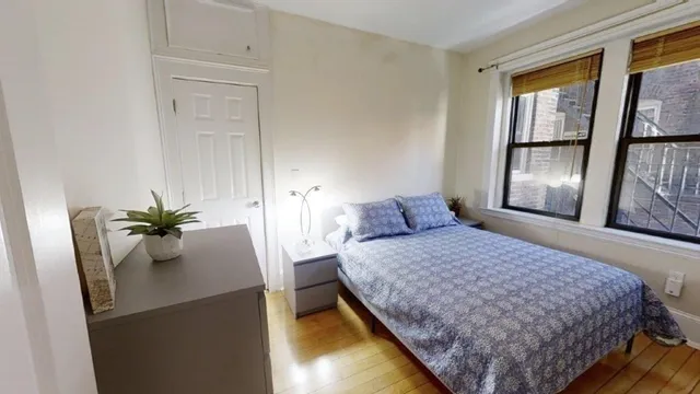 a bedroom with a bed and a potted plant