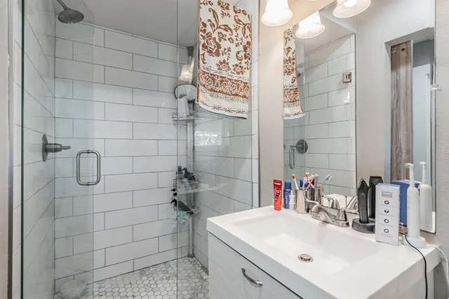 a bathroom with a sink shower and a mirror
