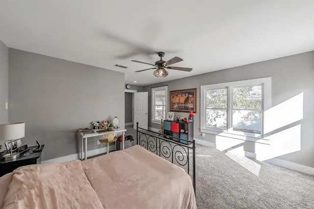 a bedroom with a bed a chandelier and a large window