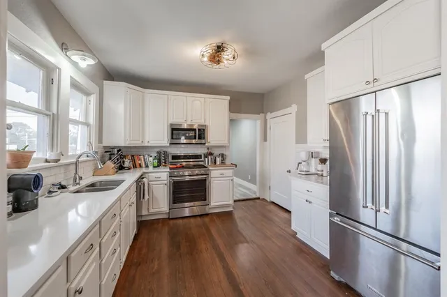 a kitchen with stainless steel appliances a refrigerator sink and cabinets