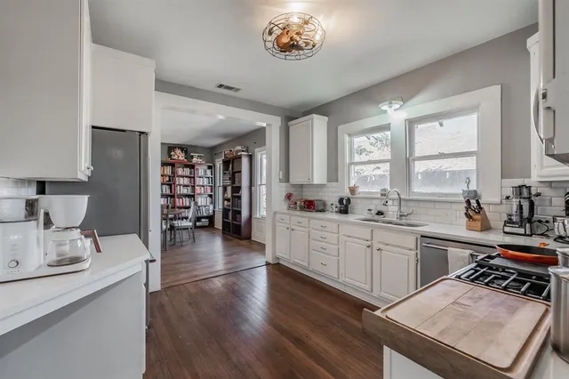 a kitchen with a sink appliances and cabinets