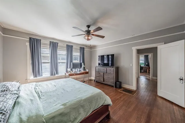 a bedroom with a large bed a large window and flat screen tv